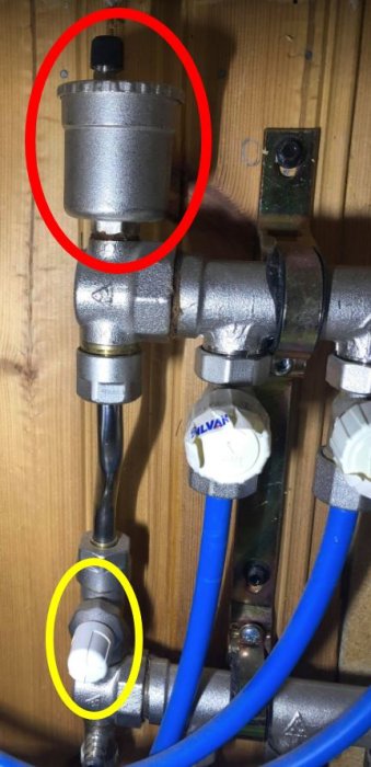 Värmesystem med rör, en automatisk avluftare ringad i rött och en möjlig låsbricka markerad med gul ring.