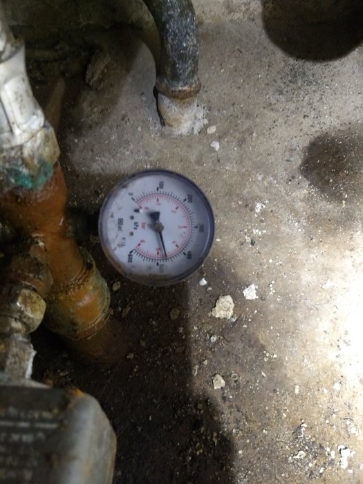 Manometer på gammalt rörverk visar tryck, för test av potentiellt läckage i tappvatten.