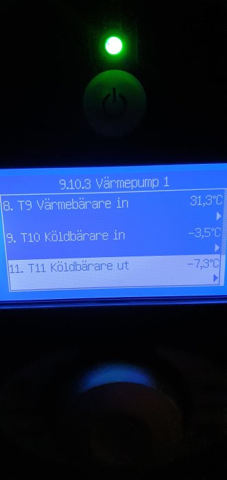 Värmepumpsdisplay visar låg temperatur för köldbärare, -3,5°C in och -7,3°C ut.