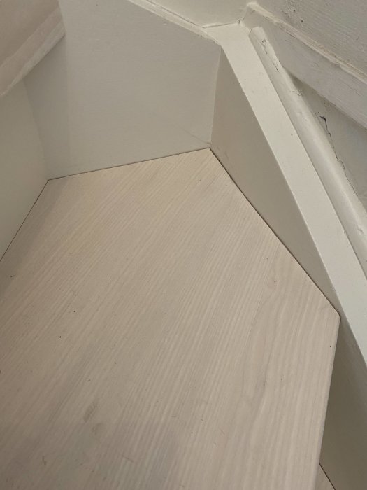 Renoverad trappsteg i trä med outfylld fog mellan steg och vitmålade sidor.