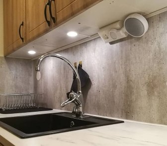 3D-utskriven hållare för Google Home monterad på köksvägg ovan diskbänk.