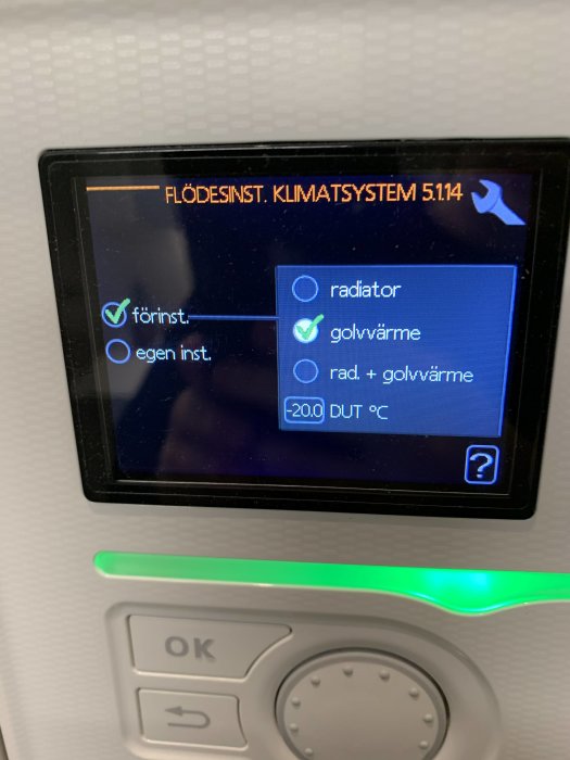 Display på en värmepump med inställningsalternativ markerade för golvvärme och 20 grader Celsius.