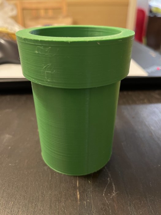 3D-utskrivet grönt Mariorör/pennställ på ett bord.