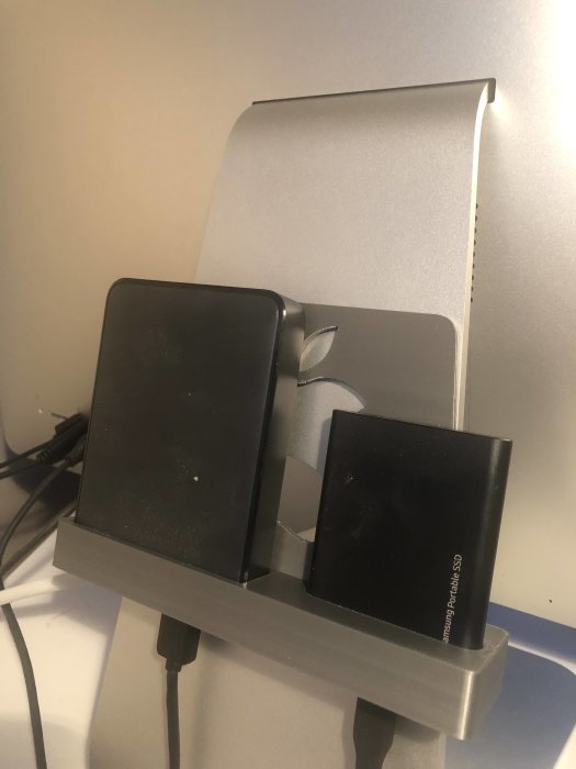 En 3D-printad hållare fäst vid en iMac med två hårddiskar monterade, en med Apple-logotyp och en med Samsung-etikett.