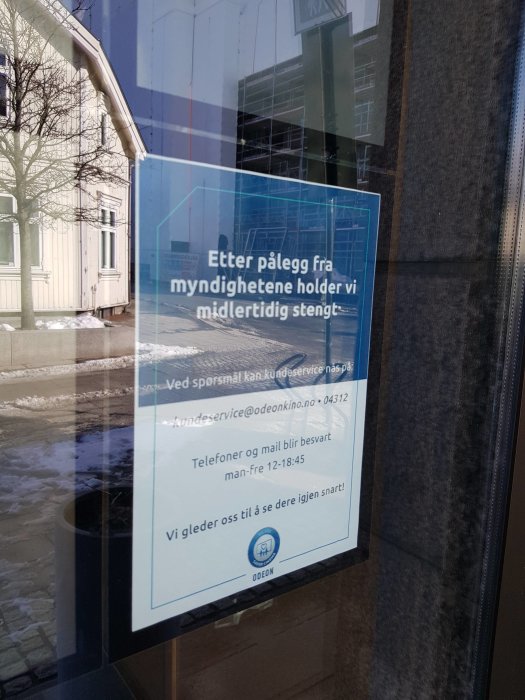 Meddelande på dörr som informerar om tillfällig stängning av biograf i Sarpsborg, Norge.