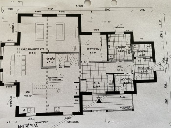 Arkitektritning av ett enfamiljshus entreplan med vardagsrum, kök, arbetsrum och badrum.