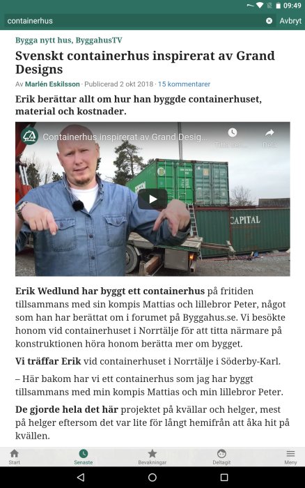 Man framför en webbsideartikel på skärmen med rubrik om svenskt containerhus och spelknapp på en video.