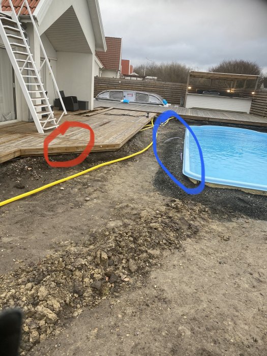 Utomhusbygge med trädäck bredvid en pool, röd cirkel visar planerad plats för transformator.