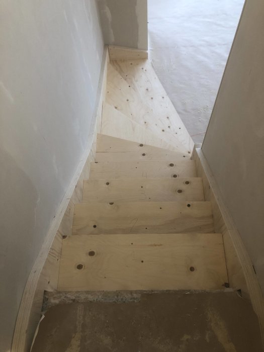 Trappa under konstruktion med steg tillverkade av 9mm plywood för passformsjustering.