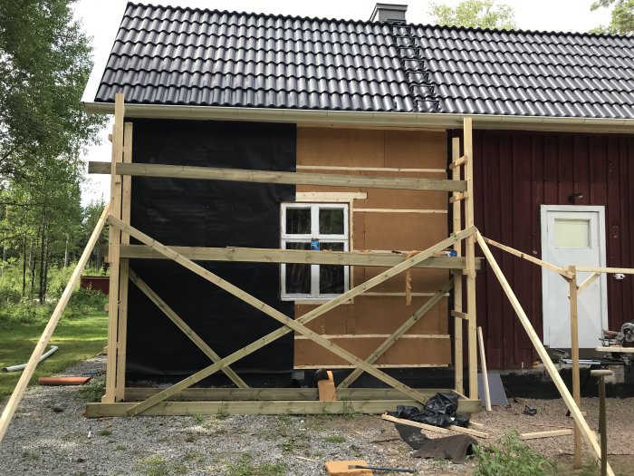 Renoveringsarbete på husfasad med 45mm reglar, huntonitplattor och vindpapp, redo för stående panel.