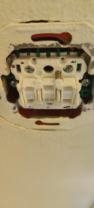 Eldosans anslutning i vägg med synliga kablar och skruvar, eventuell Renova-modell.