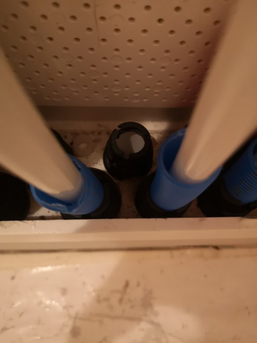 Vy inne i ett inbyggnadskåp för badrum med en ventil som inte är i nivå med skåpets botten.