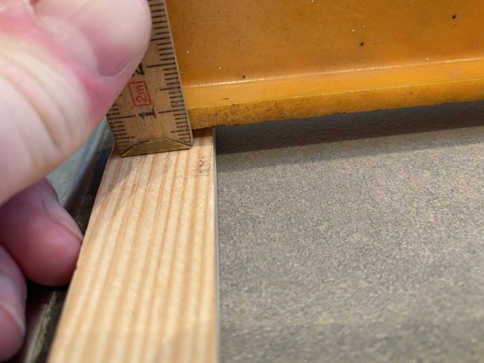 Mätning av höjdskillnad mellan klinkergolv och golvbrunnskant med tumstock.