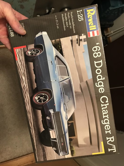 Förpackning av Revell modellkit för en '68 Dodge Charger R/T i skala 1:25 hållen i handen.