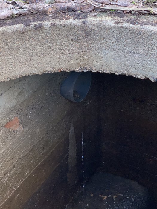Betonkub som kan vara en brunn eller jordkällare med ett rör, fråga om det är för ventilation eller avlopp.