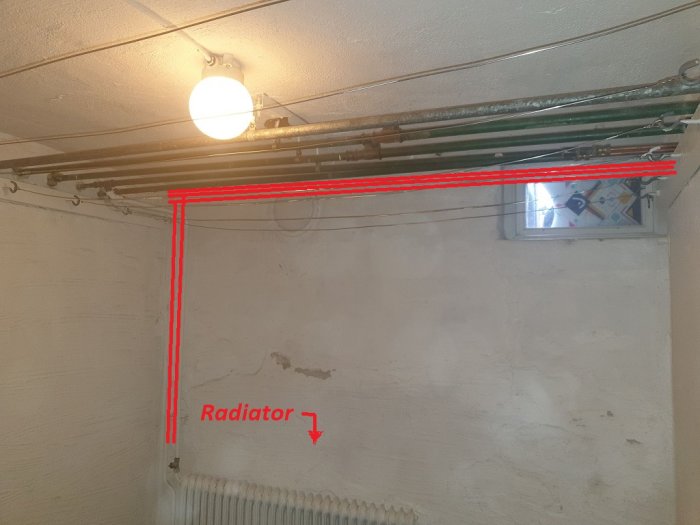 Bild på ett källarrum med synliga rör överst. Röda streck indikerar planerad omledning av rören längs väggen.