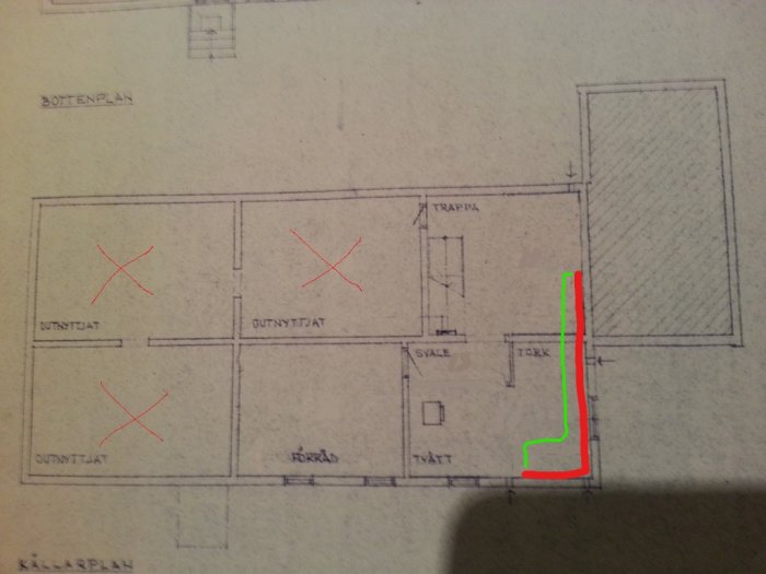 Ritning av källarplan med önskad ny rördragning markerad i rött och befintlig rördragning i grönt.