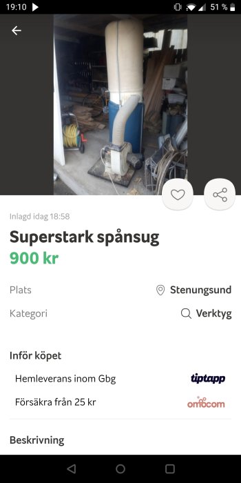 Blå spånsug i ett verkstadsutrymme med slang och spånfångarpåse.