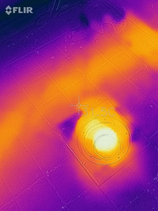 Värmekamera-bild av ett badrumsgolv som visar golvbrunn och vattenledningar med temperaturindikatorer.