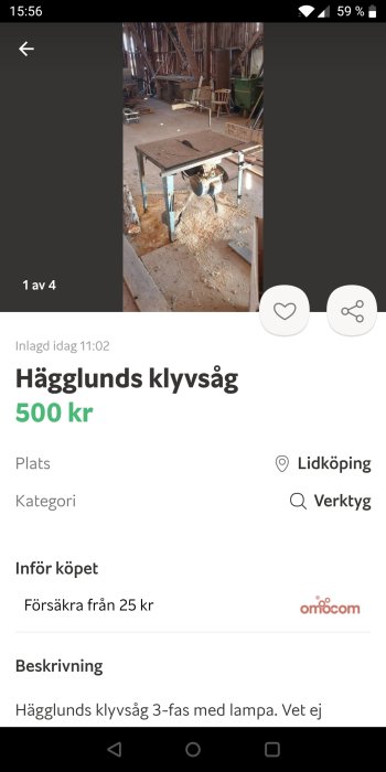 Hägglunds klyvsåg i ett rörigt verkstadsutrymme med utspridda brädor och verktyg i bakgrunden.