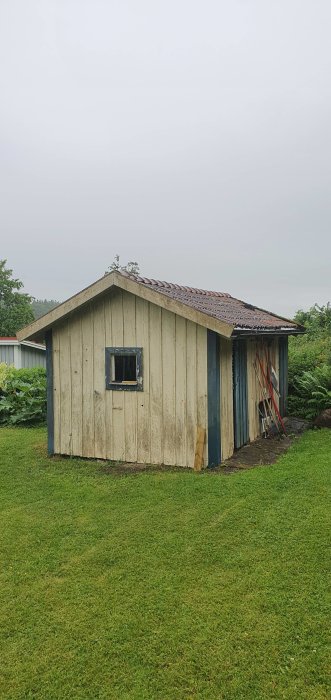 En äldre sliten bod med nymonterad ytterdörr och fotbrädor redo för målning och slutgiltiga renoveringar.