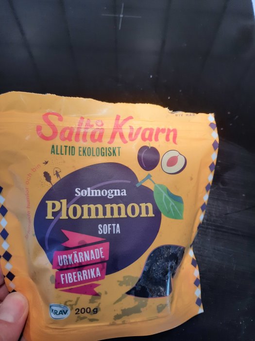 Förpackning av Saltå Kvarns ekologiska, urkärnade och mjuka plommon hålls upp.