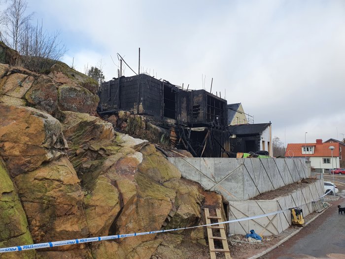 Brandskadad byggstomme av cellplastblock och betong på byggarbetsplats.