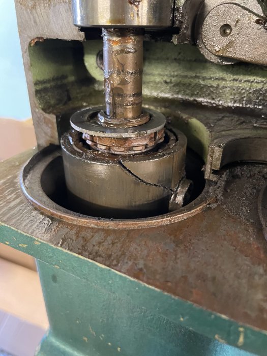 Smutsig maskinmotor med synlig olja och smuts samt en spricka vid cylinder.