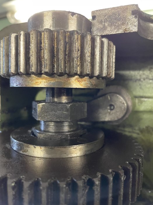Smutsig motor med fokus på kugghjul och mekaniska delar täckta i olja och smuts.