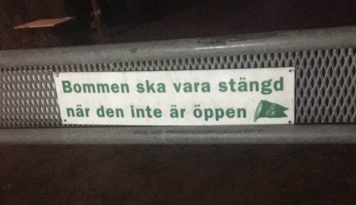 Skylt på grind med texten "Bommen ska vara stängd när den inte är öppen" och Gröndals BK-logotyp.