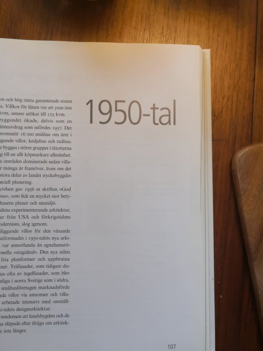 En öppnad bok med text som diskuterar 1950-talets byggnadsstil och samhällsplanering, sidtal 107 synligt i nedre högra hörnet.