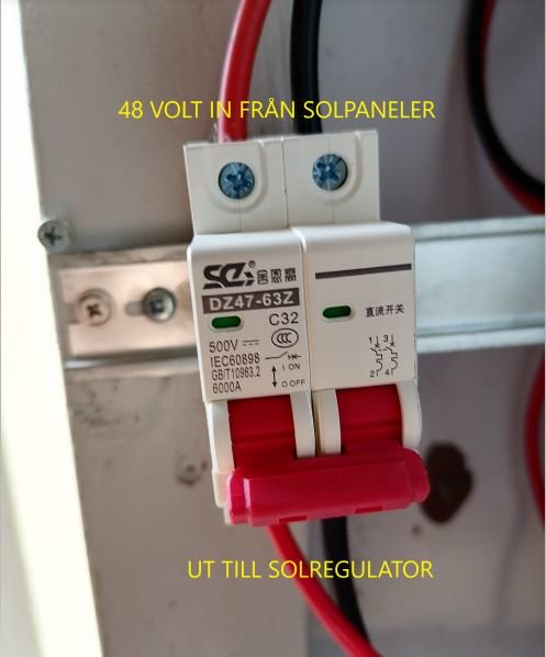Säkring i elskåp med text "48 VOLT IN FRÅN SOLPANELER" och "UT TILL SOLREGULATOR".
