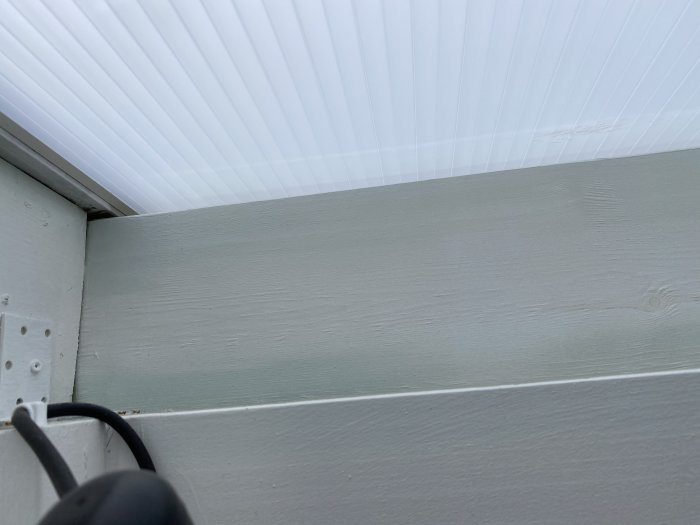 Nybyggt tak över altan med målningsproblem på impregnerat trä där färg ser ut att flagna eller ha blåsor.