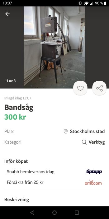 En bandsåg till salu för 300 kronor placerad i ett rum med ett fönster och byggmaterial i bakgrunden.