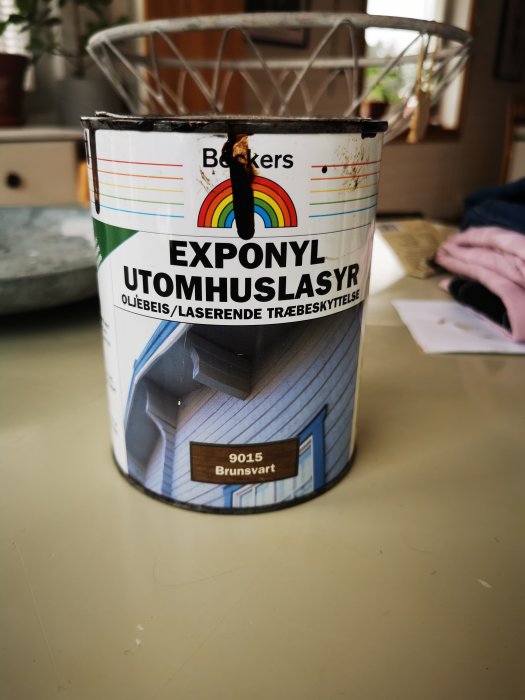 En burk mörkbrun Beckers Exponyl utomhuslasyr på ett bord.