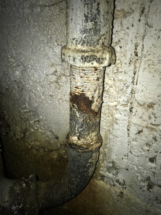 Rostigt stålrör med 34mm invändig gänga mot betongvägg i behov av anslutning till hydrofor.