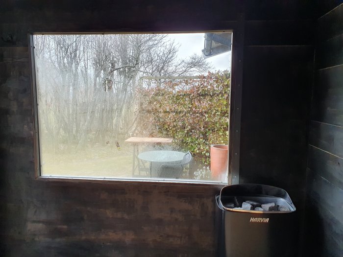 Fönstervy med imma nära bastuns elaggregat, 6mm härdat glas och utsikt över trädgården.