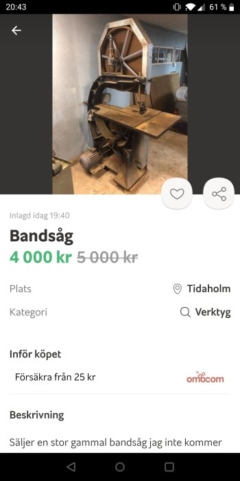 Gammal stående bandsåg i ett verkstadsutrymme till salu, visar ålderstecken och användning.