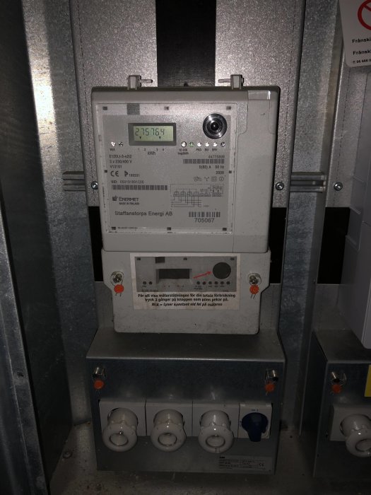 Elmätarskåp med digital display som visar 275764 i gatukabinett, med möjlighet att stänga av strömmen.