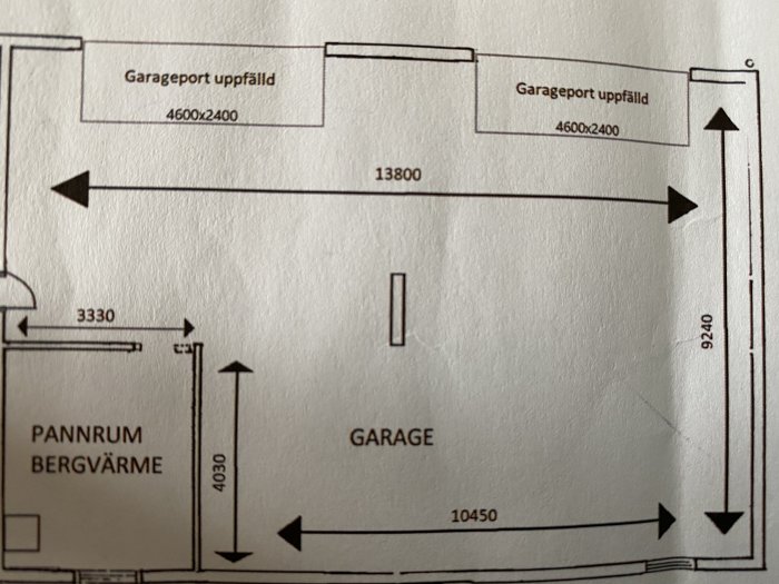 Ritning av en garageplan som visar mått för två uppfällbara garageportar, ett pannrum och angiven taklutning.