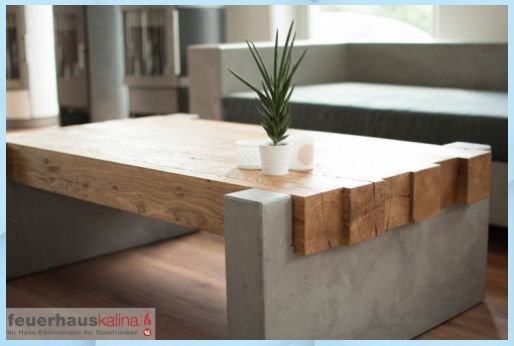Tjockt träbord med betongstöd och en kruka på ovansidan, placerat i ett modernt vardagsrum.