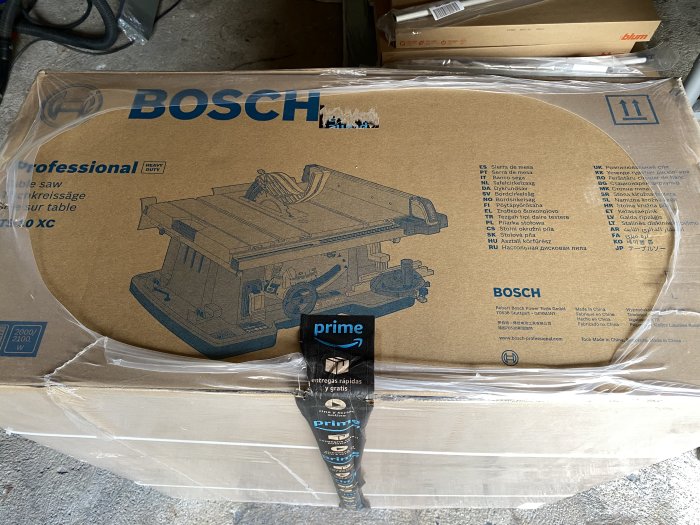 Bosch professionell bordsåg förpackning, ny och oöppnad, omgiven av plast och fraktetiketter.