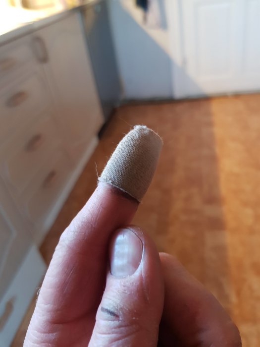 Finger med plåster efter en olycka vid snickeriarbete.