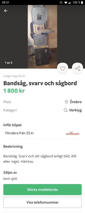 Grå stående bandsåg med arbetsbord i en verkstadsmiljö.