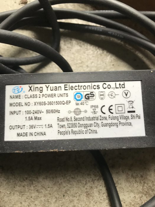 Specifikationsetikett på Xing Yuan Electronics strömadapter som visar likström 36V-1.5A utdata.