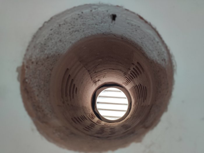 Ventilationshål i vägg, utsikt mot yttervägg med synlig struktur och tegel.
