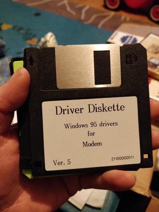 Hand håller en Windows 95 driverdiskett för modem, version 5.