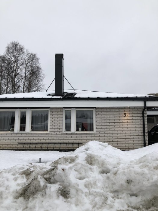 Mexitegelvilla med sättning och lutande platta vid högra hörnet, omgiven av snö.