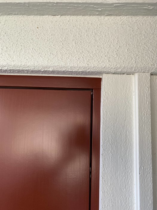 Ytterdörr som hänger snett med synlig glipa vid överkant mot karmen.