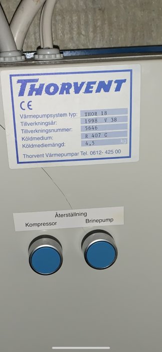Etikett på en värmepump av märket Thorvent med tekniska specifikationer och återställningsknappar för kompressor och vätskepump.